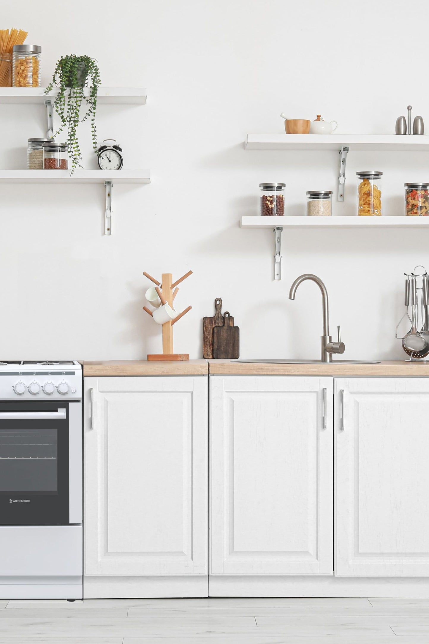 Modern kitchen with white cabinets, wooden countertops, and various kitchen appliances.