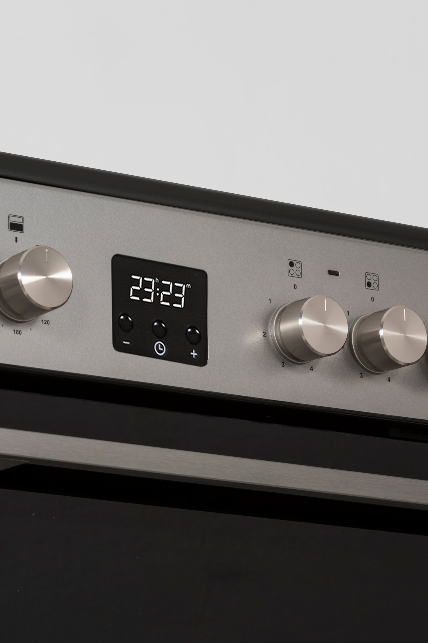 Stainless steel oven with digital display and control knobs on a gray background