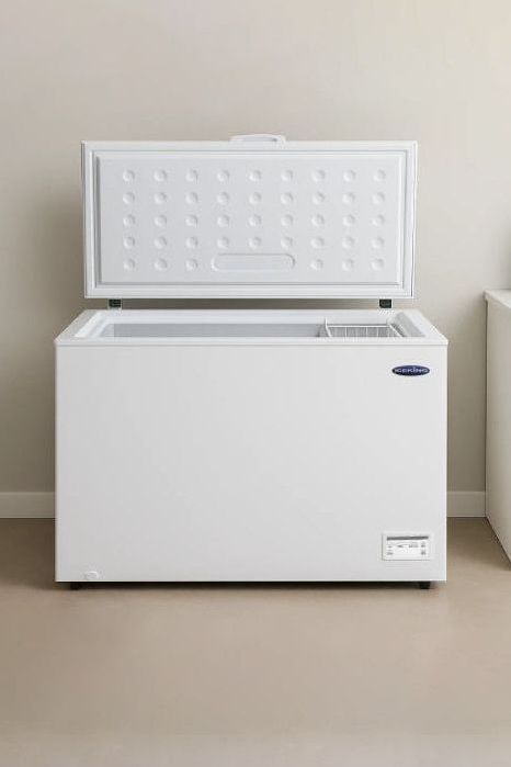 White chest freezer next to a washing machine in a laundry room.