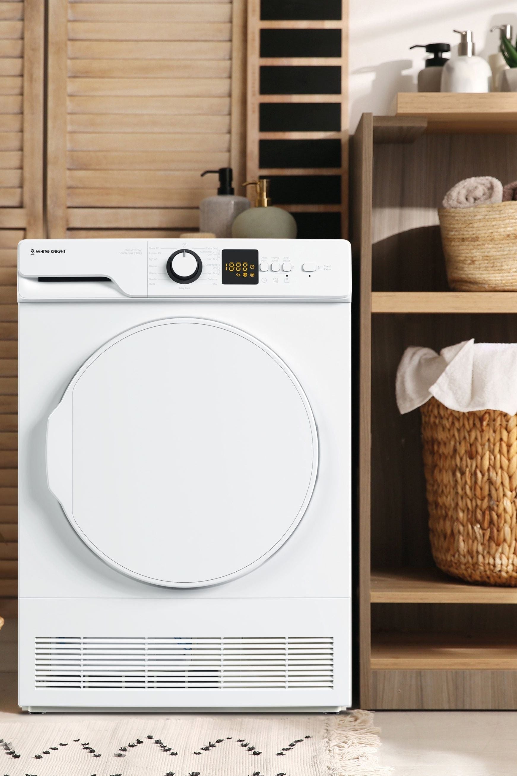 White dryer in a laundry room with wooden shelves and baskets.