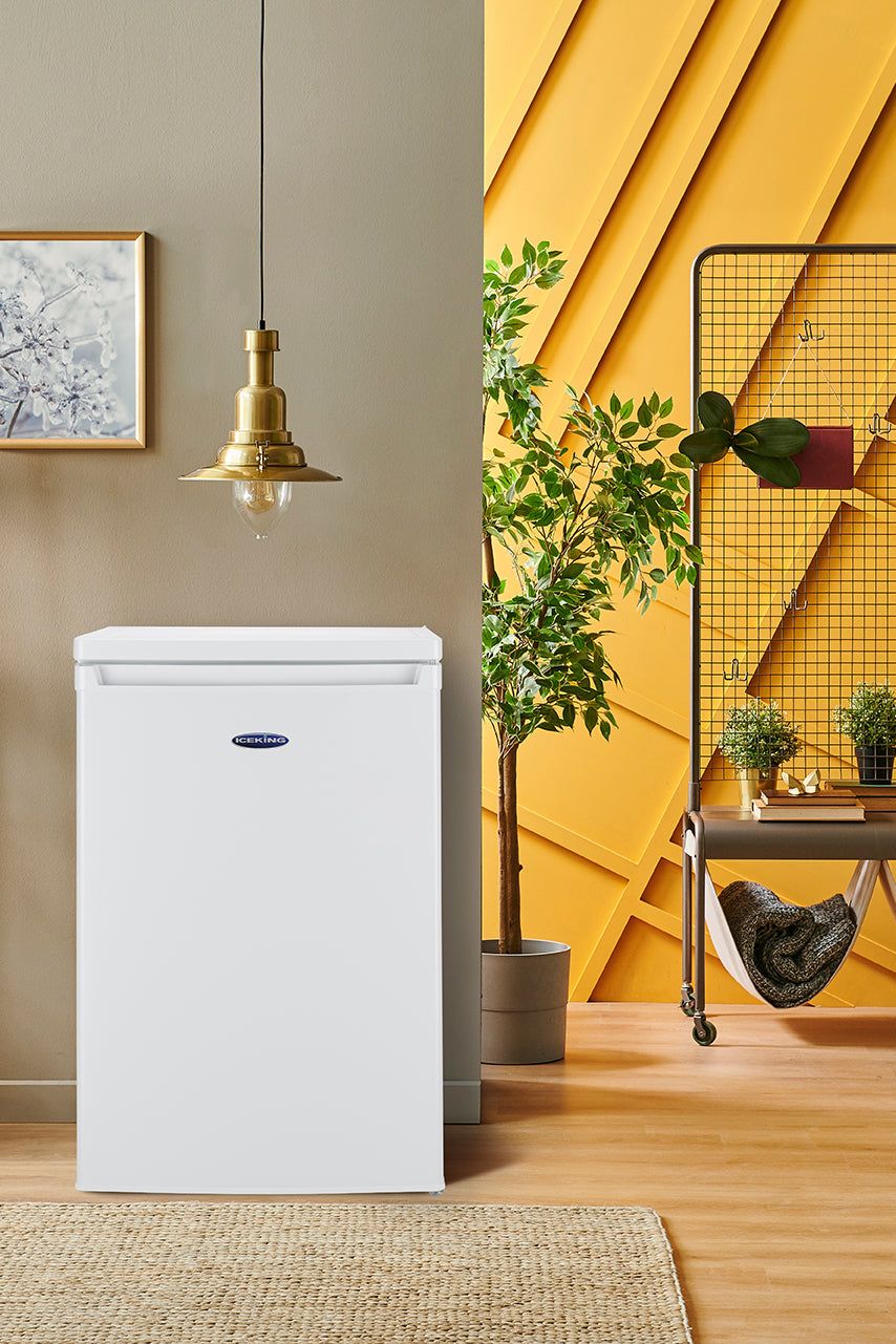 White refrigerator in a room with yellow walls, plants, and shelves.
