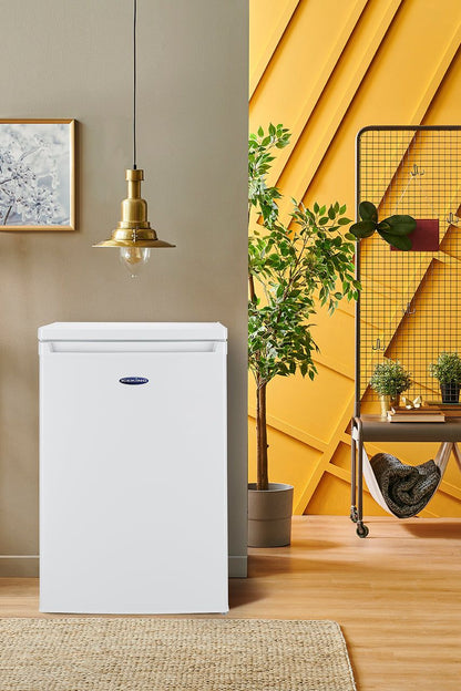 White refrigerator in a room with yellow walls, plants, and shelves.